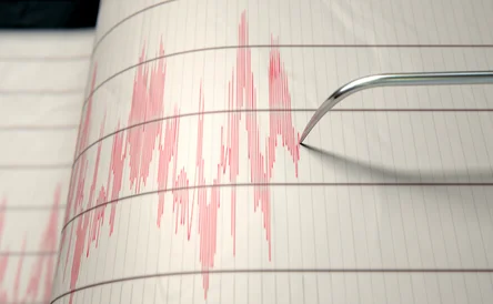 A closeup of a seismograph machine needle drawing a red line on graph paper depicting seismic and eartquake activity - 3D render